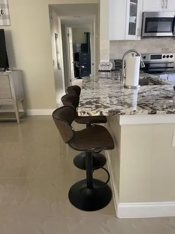 a kitchen with stainless steel appliances granite countertop a sink a stove and a wooden floors