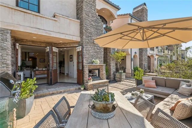 a view of a patio with couches table and chairs under an umbrella