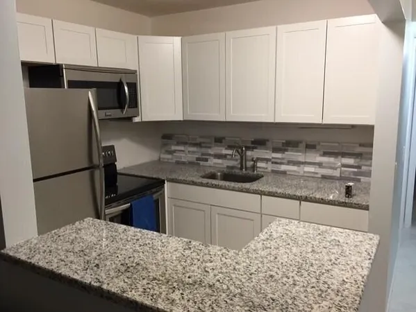 a kitchen with a sink refrigerator and microwave