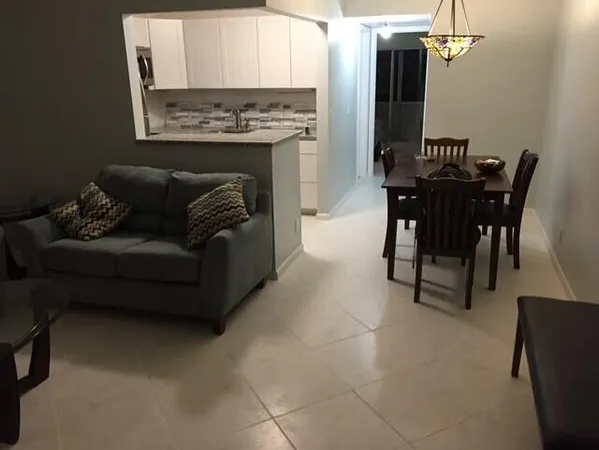 a living room with furniture a fireplace and a chandelier