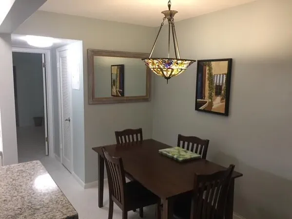 a view of a dining room with a table and chairs