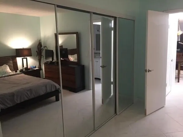 a bedroom with a large bed and a mirror