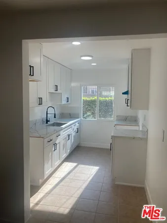 a kitchen with a sink cabinets and window
