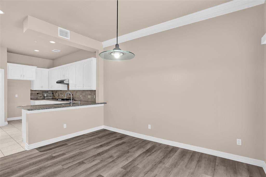 4092 Oberlin Way Addison, TX 75001 - Photo 13 of 40 Kitchen featuring dark stone countertops, a peninsula, decorative backsplash, white cabinetry, and recessed lighting
