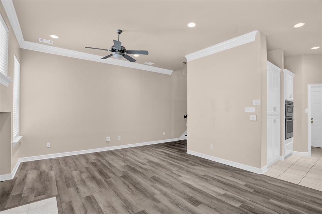 4092 Oberlin Way Addison, TX 75001 - Photo 14 of 40 Empty room with ceiling fan, ornamental molding, light wood finished floors, baseboards, and recessed lighting