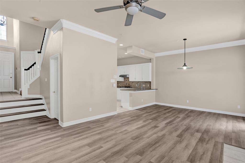 4092 Oberlin Way Addison, TX 75001 - Photo 5 of 40 Unfurnished living room with ornamental molding, recessed lighting, light wood finished floors, baseboards, and stairway