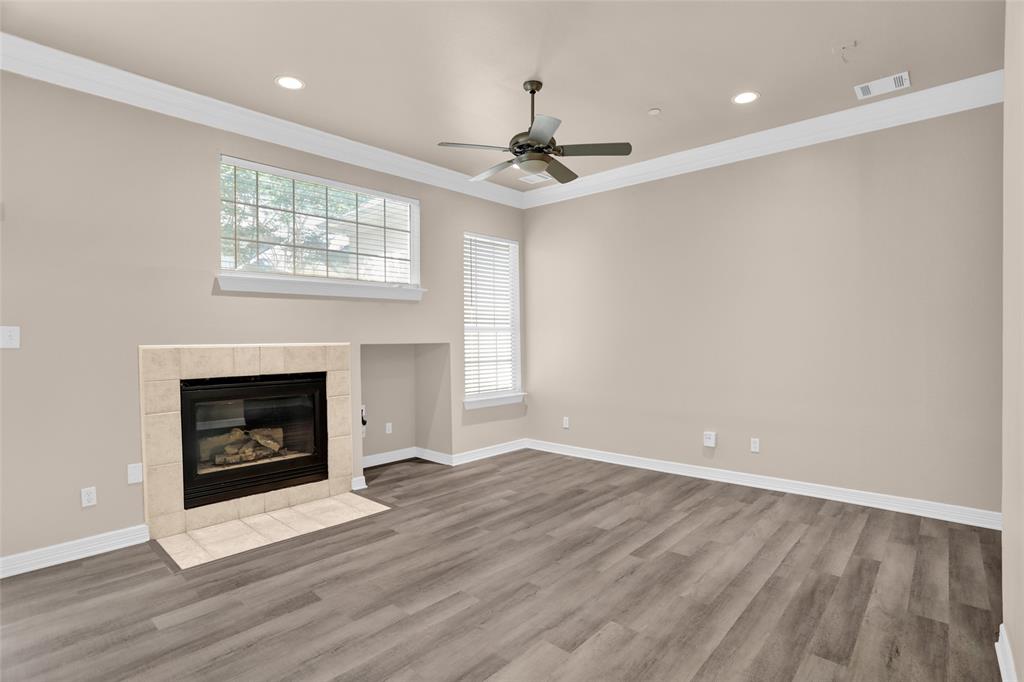 4092 Oberlin Way Addison, TX 75001 - Photo 7 of 40 Unfurnished living room with crown molding, wood finished floors, a fireplace, ceiling fan, and recessed lighting