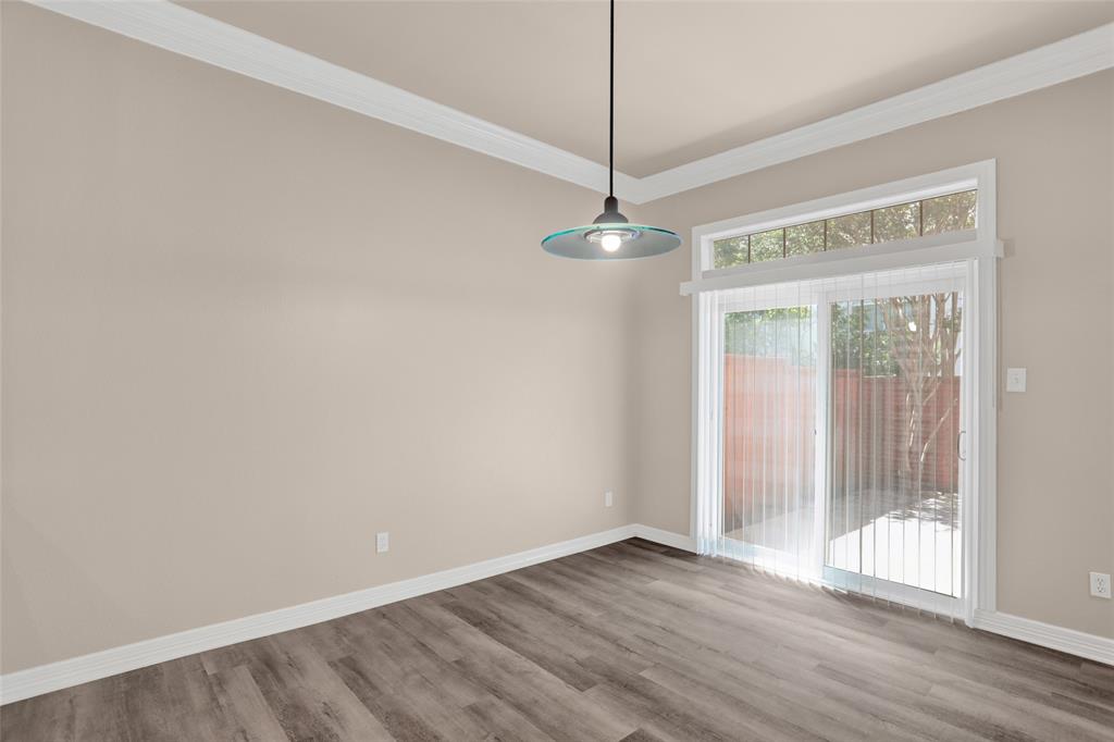 4092 Oberlin Way Addison, TX 75001 - Photo 10 of 40 Unfurnished dining area with wood finished floors, baseboards, and crown molding