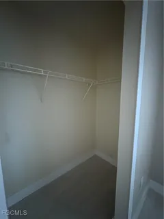 an empty room with a ceiling fan and a window