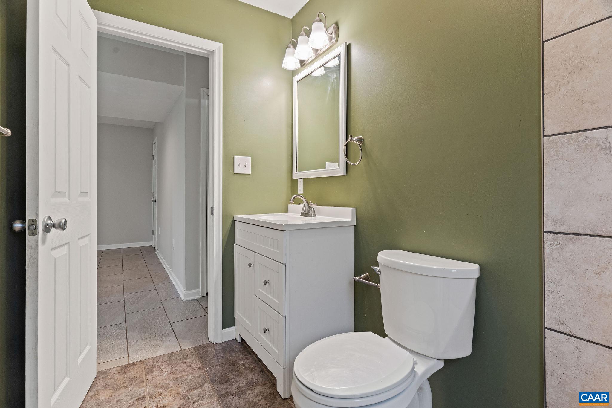 569 Half Mile Branch Road Crozet, VA 22932 - Photo 23 of 35 a bathroom with a sink a toilet a mirror and vanity