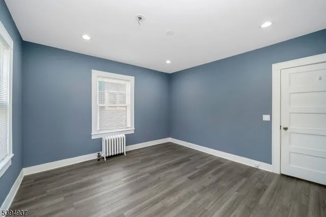 an empty room with wooden floor and window