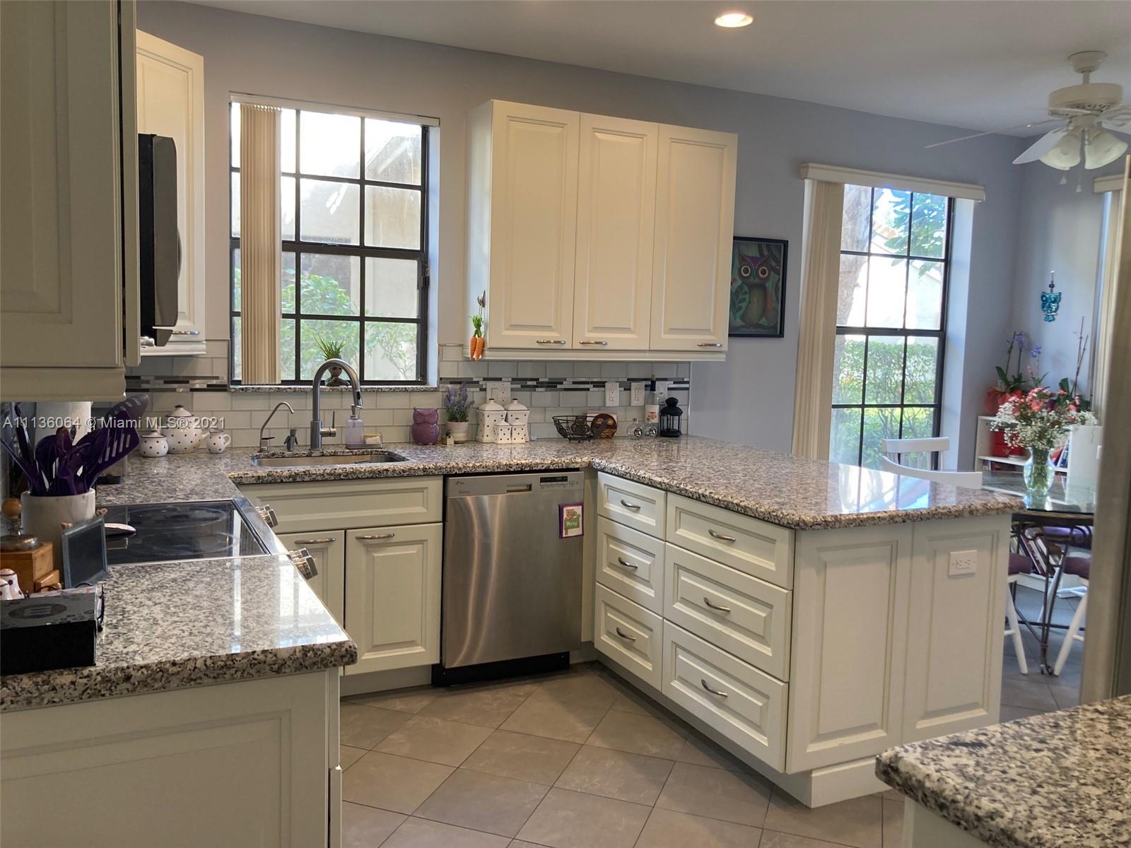 6765 Montego Bay Boulevard, Unit E Boca Raton, FL 33433 - Photo 13 of 31 a kitchen with stainless steel appliances granite countertop a sink stove and cabinets