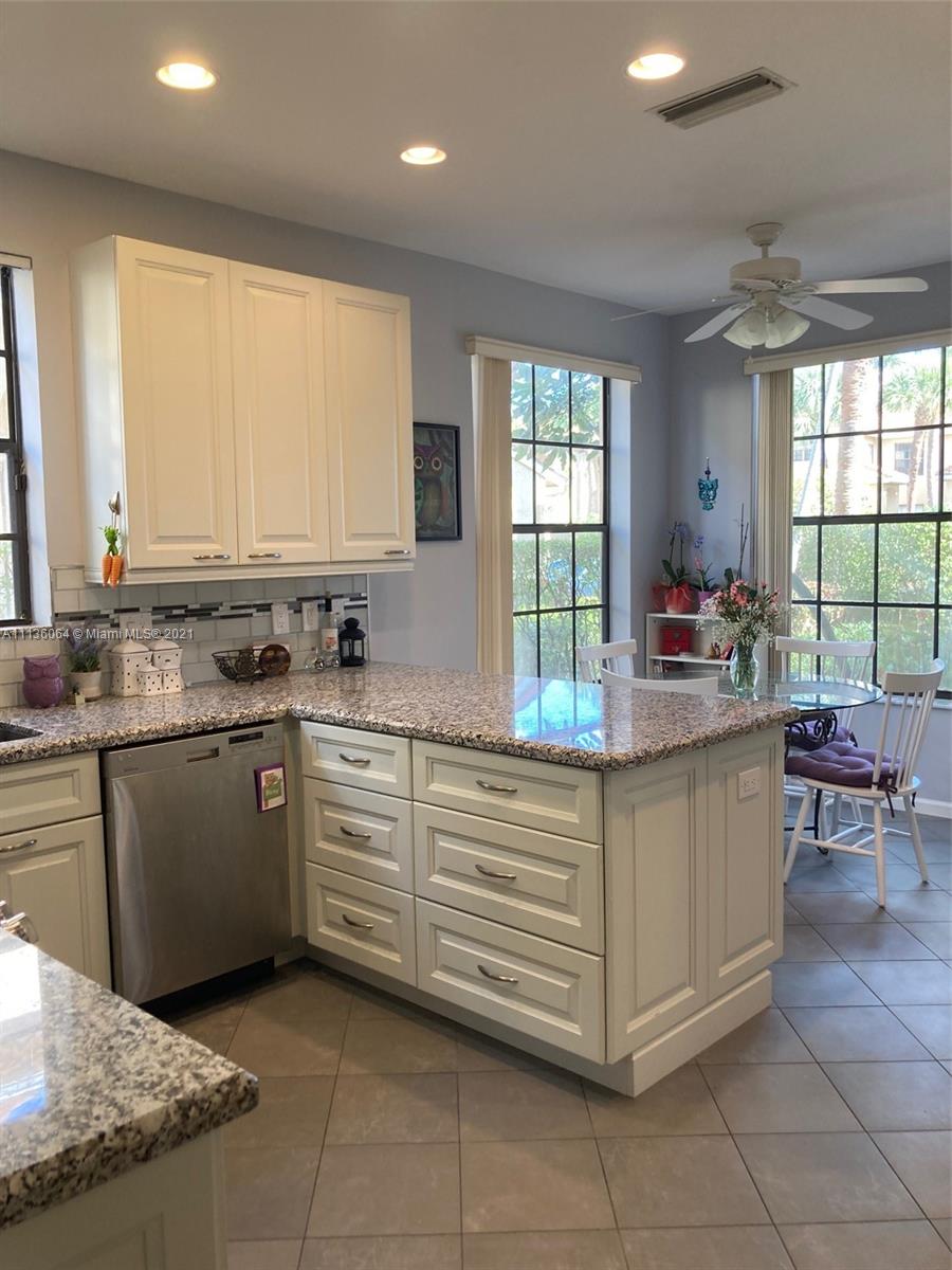 6765 Montego Bay Boulevard, Unit E Boca Raton, FL 33433 - Photo 14 of 31 a kitchen with stainless steel appliances granite countertop a sink and cabinets