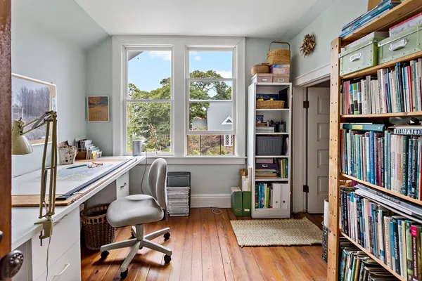 a view of a workspace with furniture and a book shelf