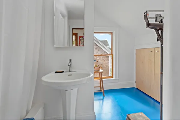 a bathroom with a sink a mirror and wooden floor