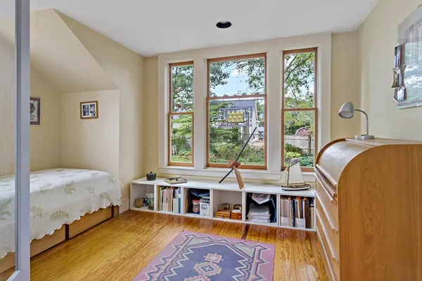 a large bedroom with a bed and wooden floor