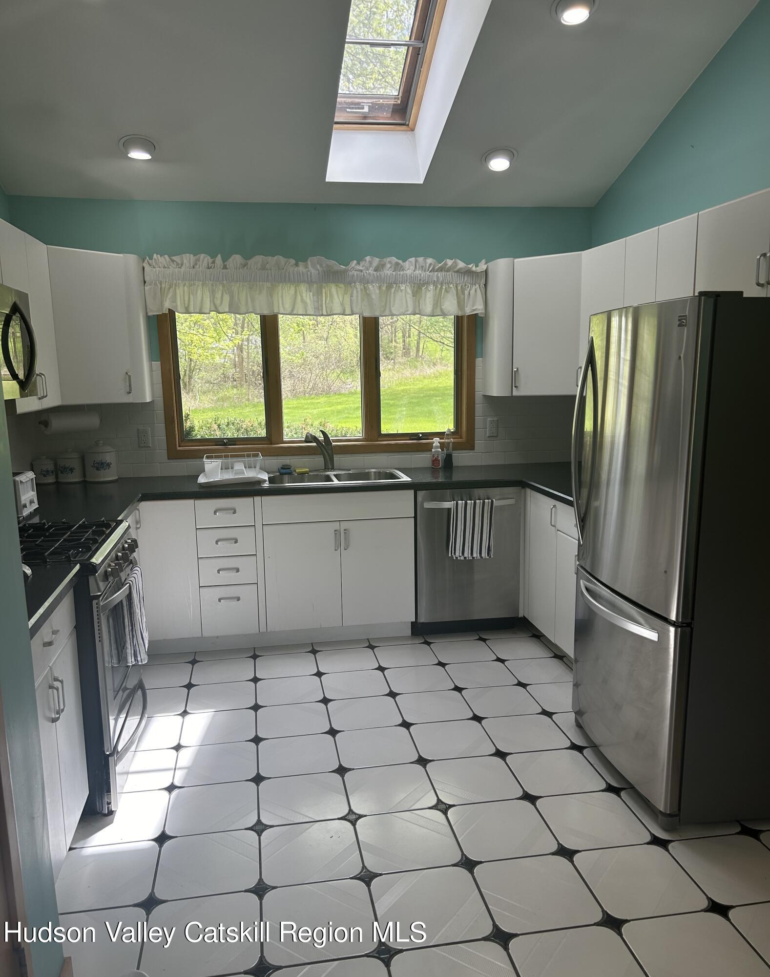 40 Tillson Lake Road Wallkill, NY 12589 - Photo 24 of 42 a kitchen with stainless steel appliances granite countertop a sink a stove a refrigerator a washer dryer and a window