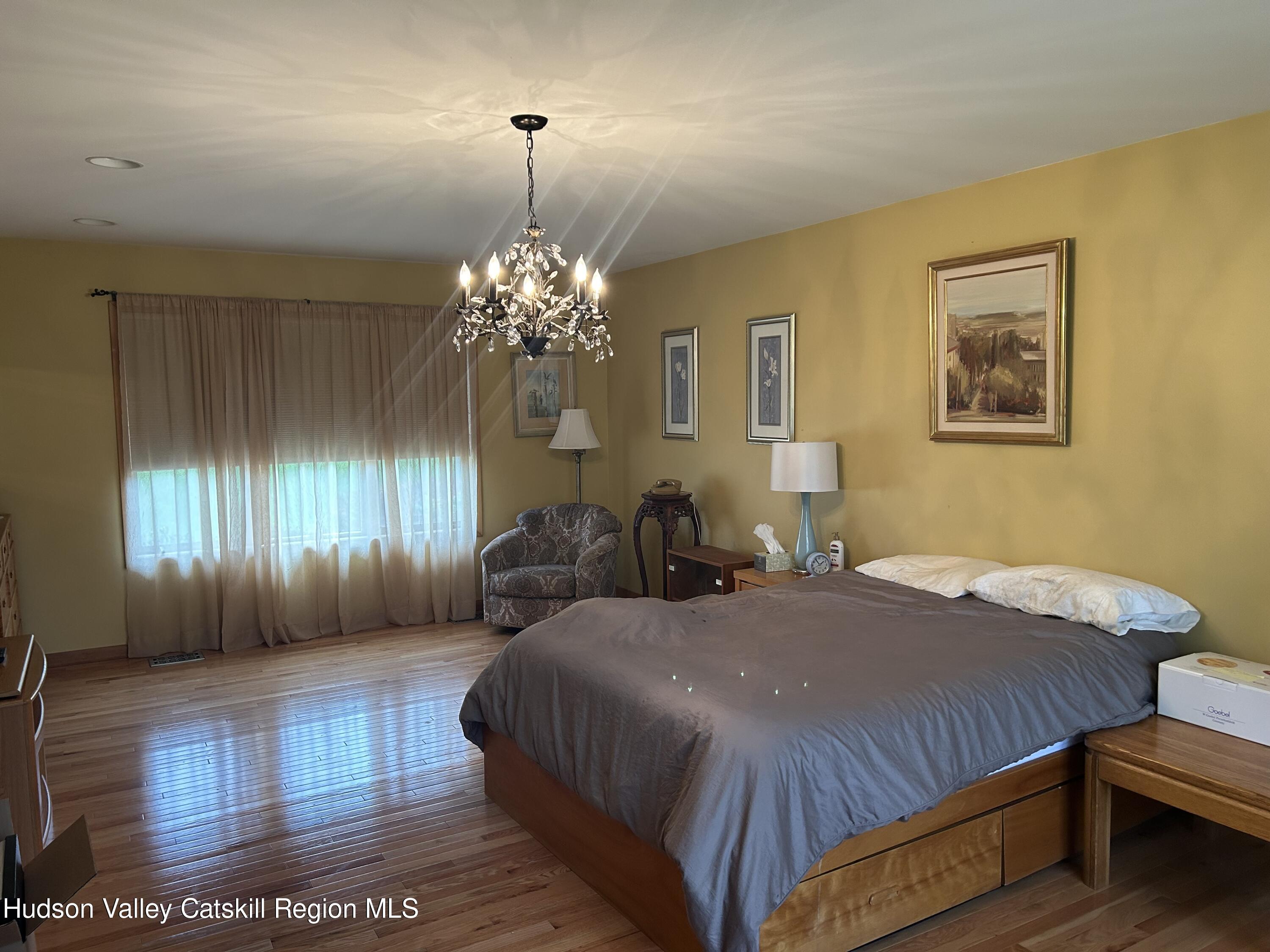 40 Tillson Lake Road Wallkill, NY 12589 - Photo 26 of 42 a bedroom with a bed and a chandelier