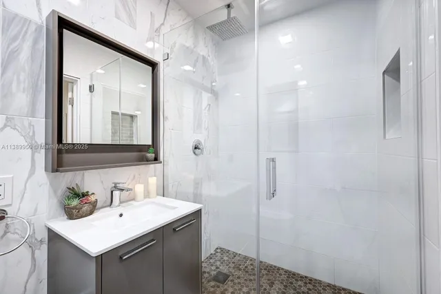 a bathroom with a sink a toilet a shower and a mirror