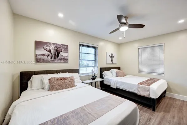 a bedroom with two beds and painting on the wall