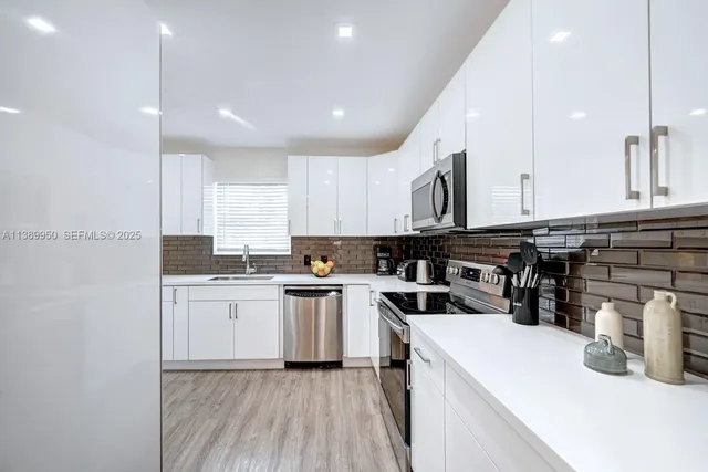 a kitchen with a sink a stove and cabinets