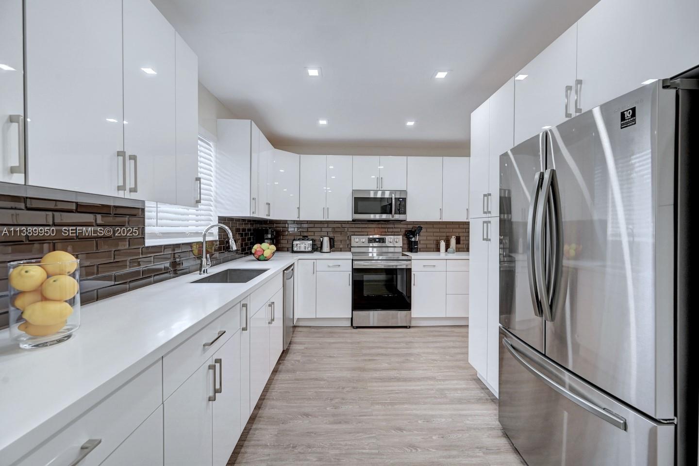 801 Harrison Street Hollywood, FL 33019 - Photo 36 of 46 a kitchen with stainless steel appliances a refrigerator sink and cabinets
