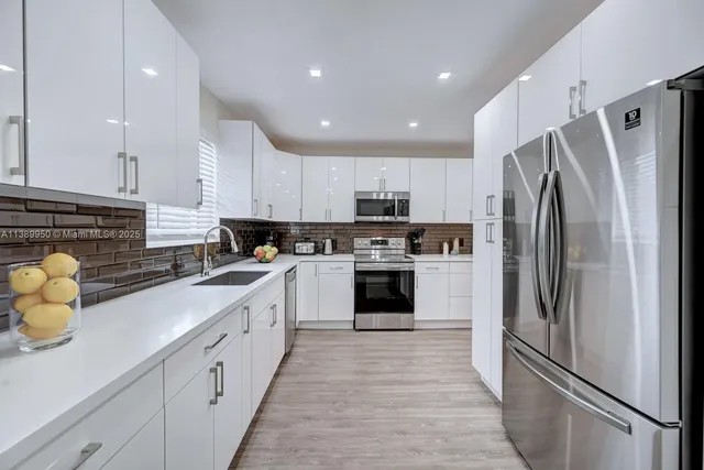 a kitchen with stainless steel appliances a refrigerator sink and cabinets
