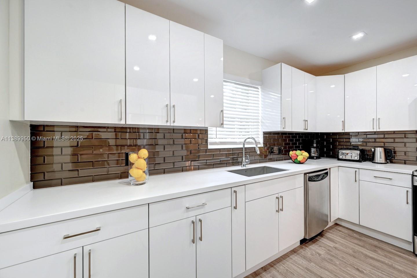 801 Harrison Street Hollywood, FL 33019 - Photo 37 of 46 a kitchen with a sink dishwasher a white stove and cabinets with wooden floor