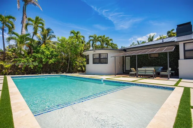 a view of a house with swimming pool and sitting area