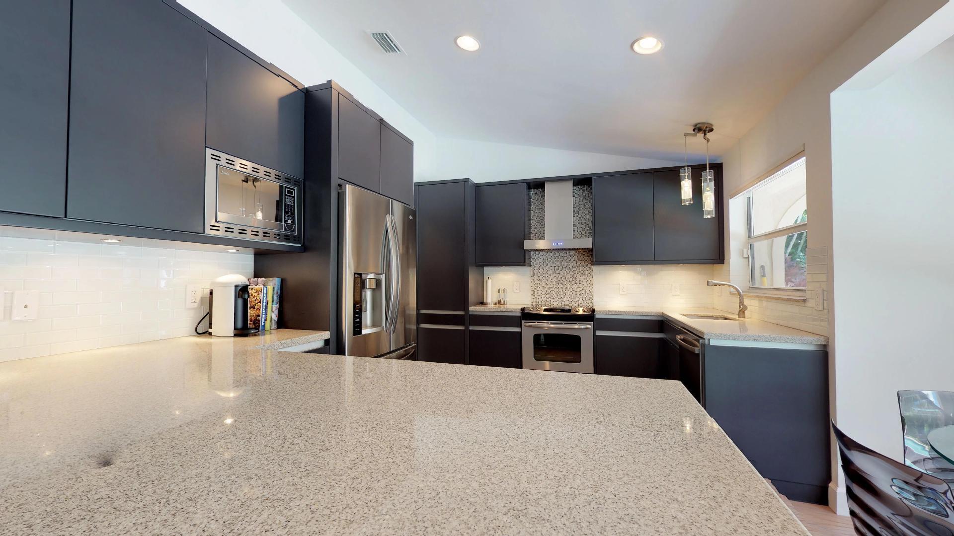 5264 Deerhurst Crescent Circle Boca Raton, FL 33486 - Photo 18 of 62 a kitchen with stainless steel appliances granite countertop a refrigerator stove microwave and sink