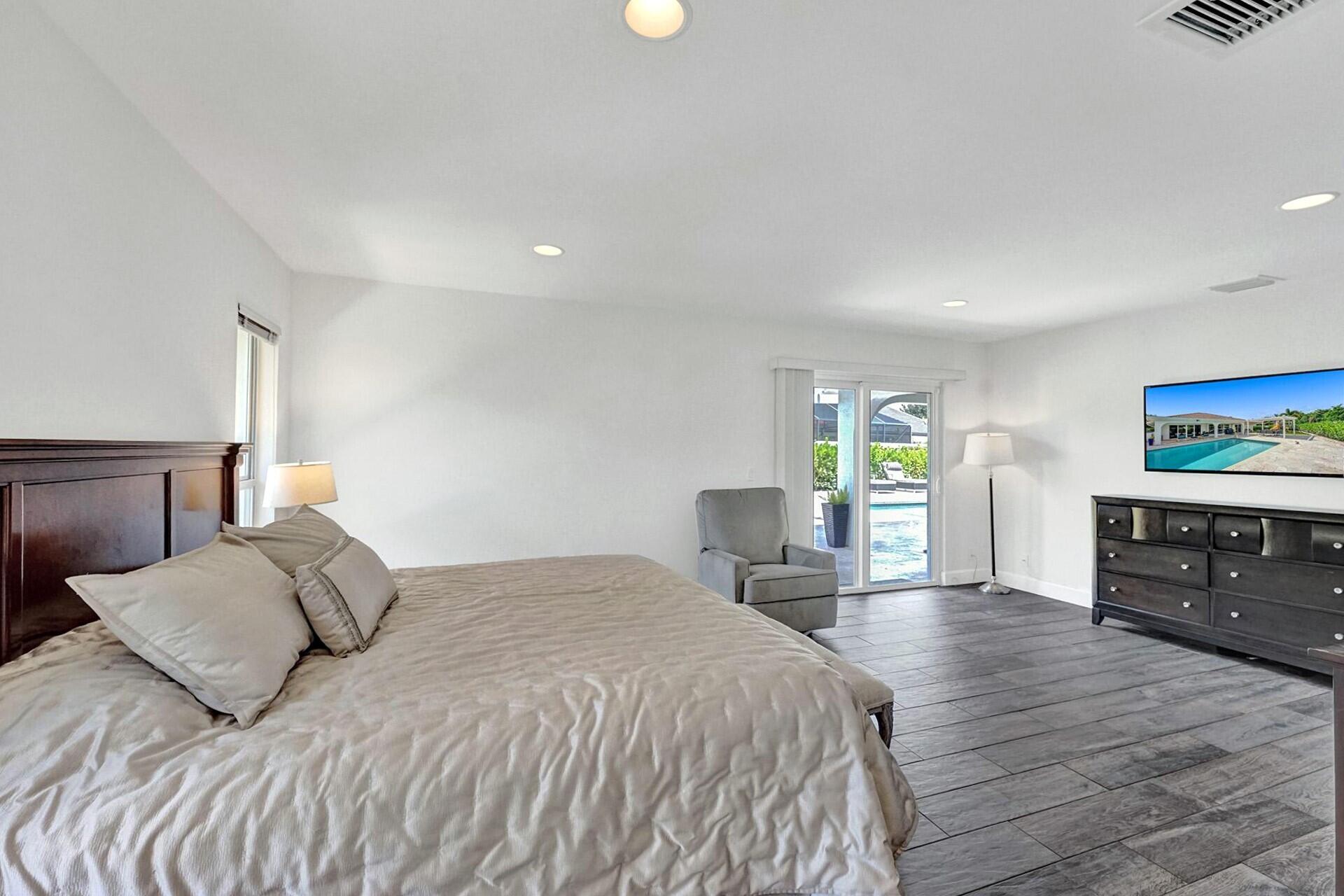 5264 Deerhurst Crescent Circle Boca Raton, FL 33486 - Photo 29 of 62 a bedroom with a bed and wooden floor