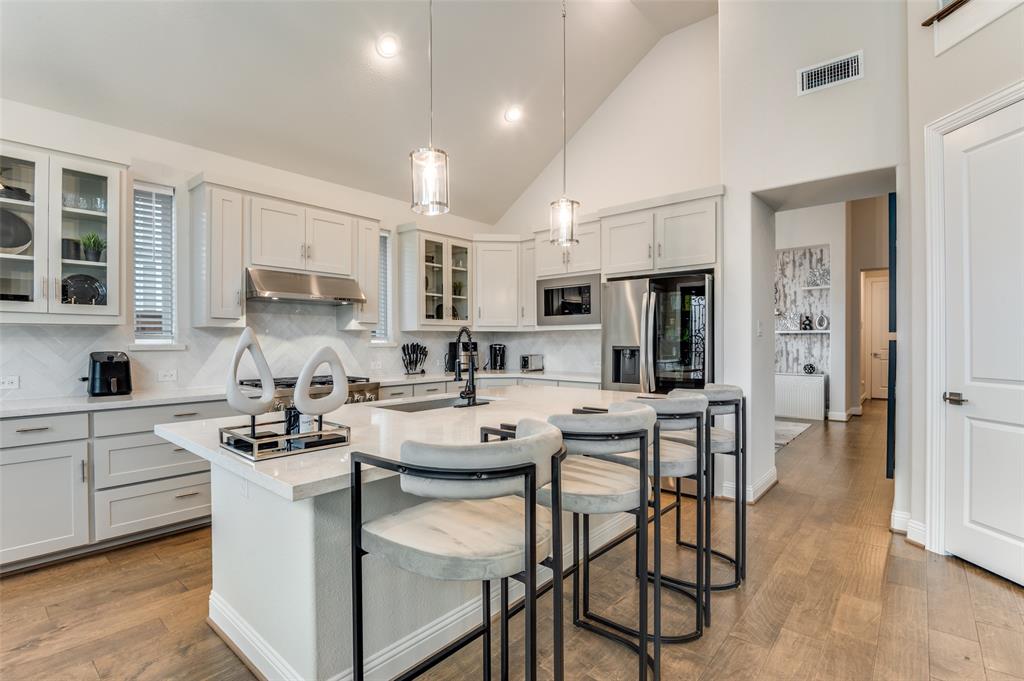 2417 Shane Drive Midlothian, TX 76065 - Photo 12 of 40 a kitchen with stainless steel appliances a table chairs refrigerator and cabinets