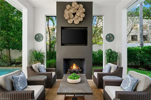a living room with furniture a fireplace and a large window