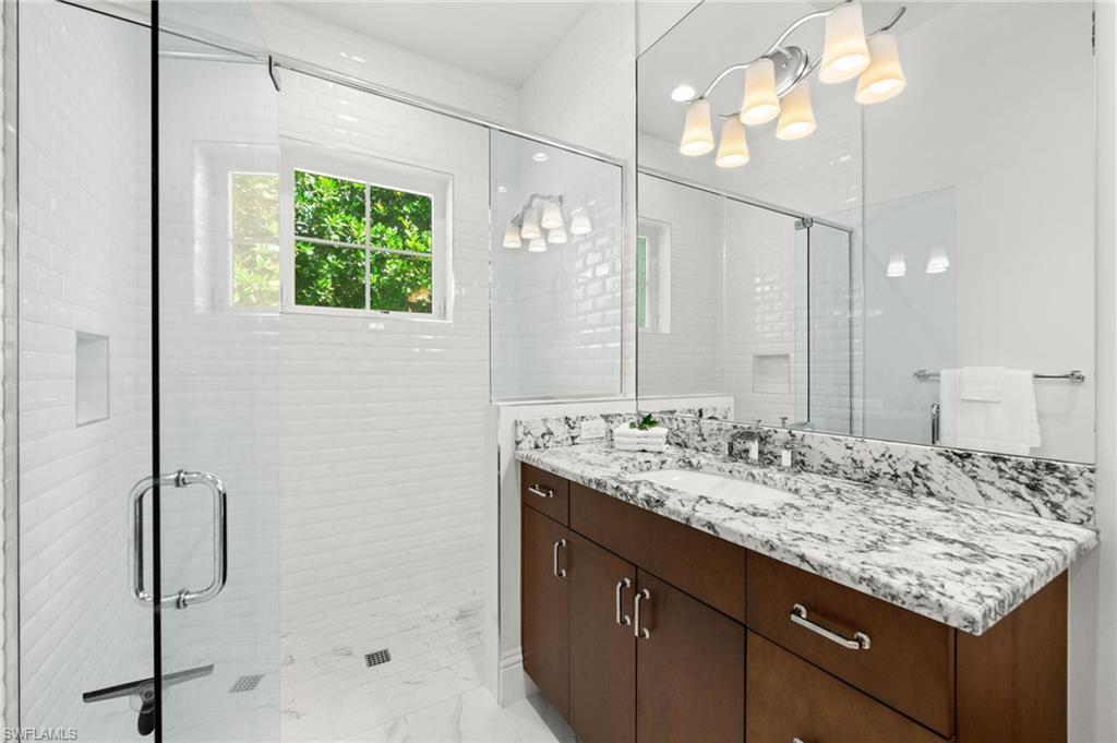 9172 Mercato Lane Naples, FL 34108 - Photo 18 of 29 Bathroom featuring vanity, a shower stall, and light marble finish flooring