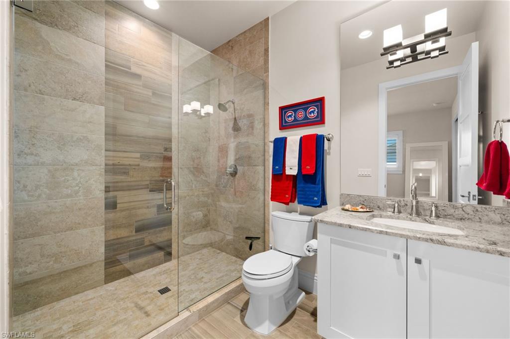 9172 Mercato Lane Naples, FL 34108 - Photo 21 of 29 Bathroom featuring vanity, a shower stall, wood finish floors, and recessed lighting