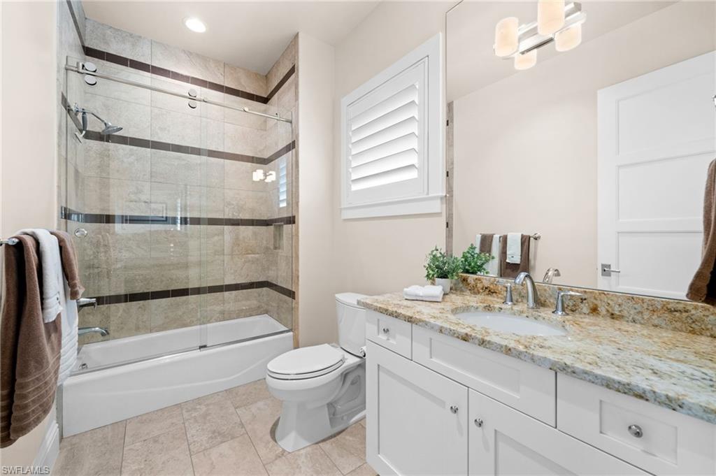 9172 Mercato Lane Naples, FL 34108 - Photo 24 of 29 Full bathroom with vanity, bath / shower combo with glass door, and light tile patterned floors