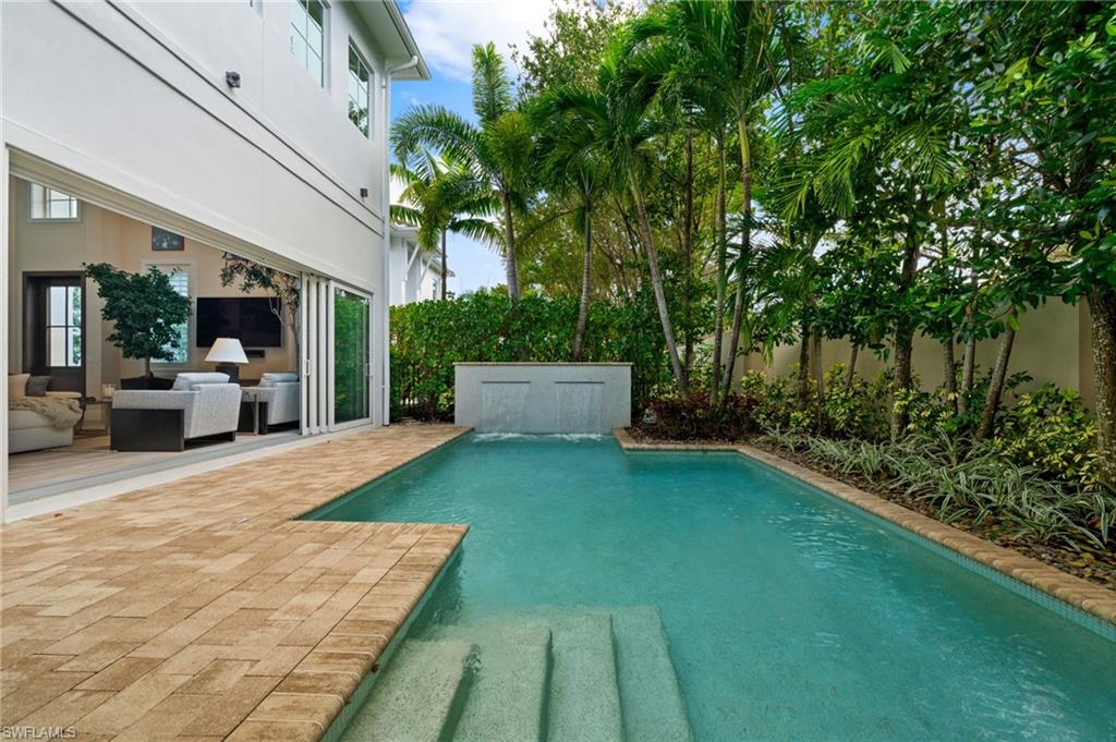 9172 Mercato Lane Naples, FL 34108 - Photo 27 of 29 View of swimming pool featuring patio surround, a fenced backyard, and an outdoor hangout area