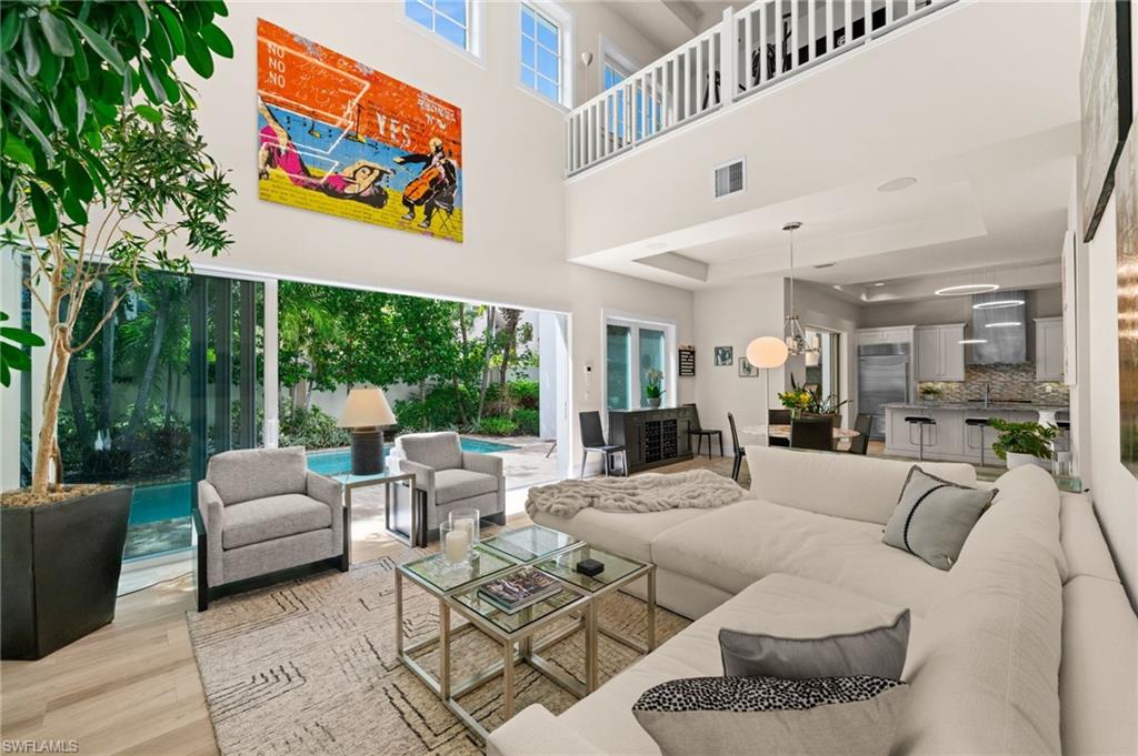 9172 Mercato Lane Naples, FL 34108 - Photo 7 of 29 Living room with light wood finished floors and a high ceiling
