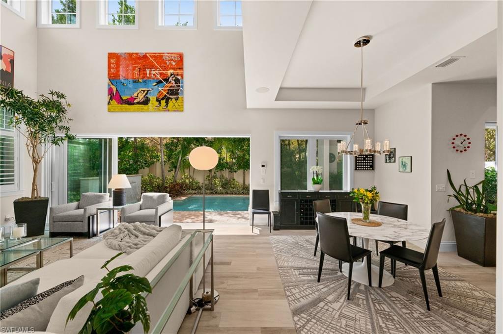 9172 Mercato Lane Naples, FL 34108 - Photo 8 of 29 Living area with wood finished floors, suspended lighting, and a tray ceiling