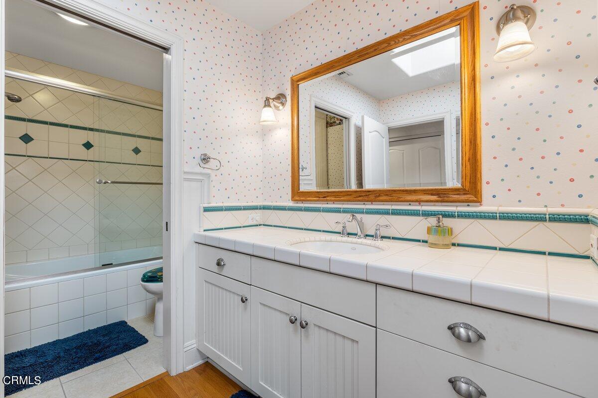 4530 Lyme Bay Oxnard, CA 93035 - Photo 17 of 46 a bathroom with a sink and a mirror with bathtub