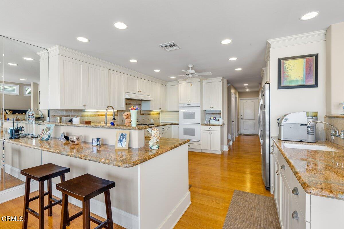 4530 Lyme Bay Oxnard, CA 93035 - Photo 10 of 46 a kitchen with stainless steel appliances granite countertop a sink and a refrigerator