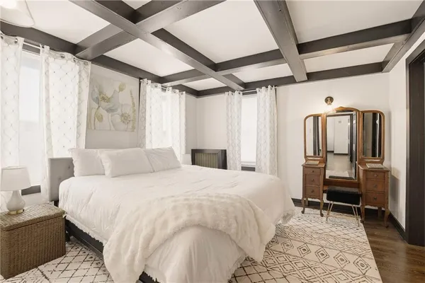 a bedroom with a bed next to a window and a chair