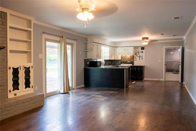 a view of a kitchen with a stove wooden floor and a kitchen
