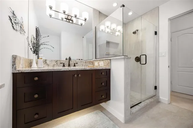 a bathroom with a double vanity sink mirror and shower