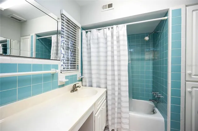 a bathroom with a granite countertop sink and a bathtub
