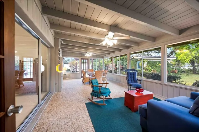 a living room with patio furniture and a floor to ceiling window
