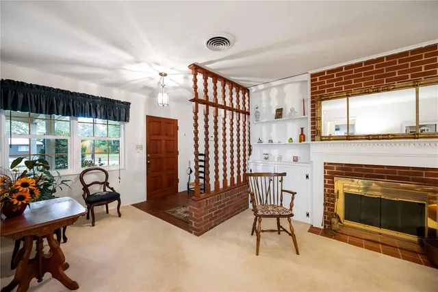 a living room with furniture a fireplace and a floor to ceiling window
