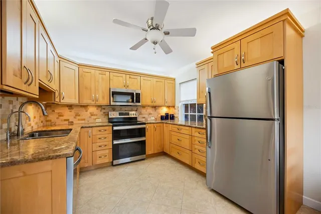a kitchen with stainless steel appliances granite countertop a refrigerator a stove a sink and dishwasher