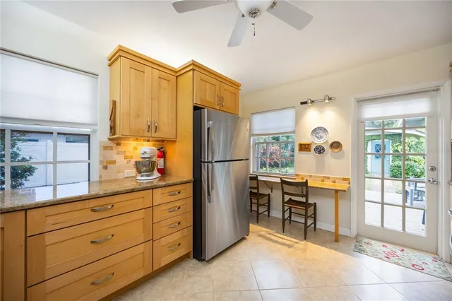 a kitchen with refrigerator cabinets and large windows