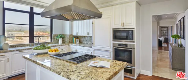 a kitchen with stainless steel appliances granite countertop a stove a refrigerator and a sink